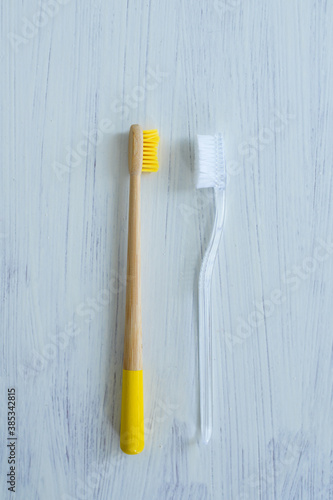 Wooden and plastic toothbrushes layin gon the white background photo