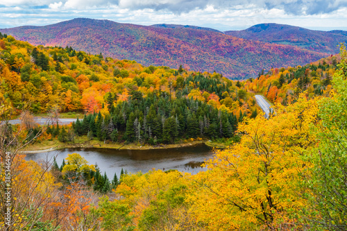 road winds through the Appalachian Gap  a mountain pass in the Green Mountains of Vermont  in bright colored fall foliage 