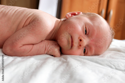 cute newborn child infant with serious face ready to sleep close up