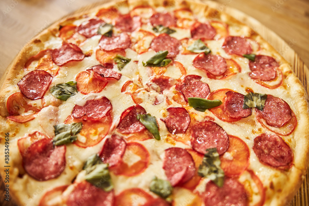 Freshly baked pepperoni pizza on wooden board Freshly baked pepperoni pizza on wooden board