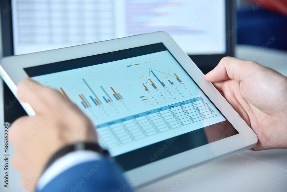 Hands using tablet device with business report Hands using tablet device with business report