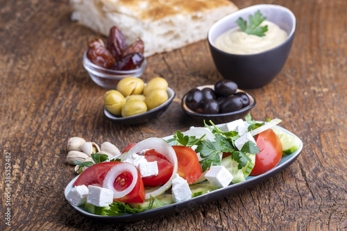 olives and hummus on dark wood photo