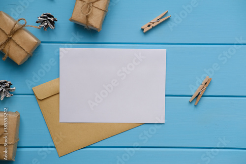 Mock up of a white greeting card on blue wooden textured table. Place for a text.