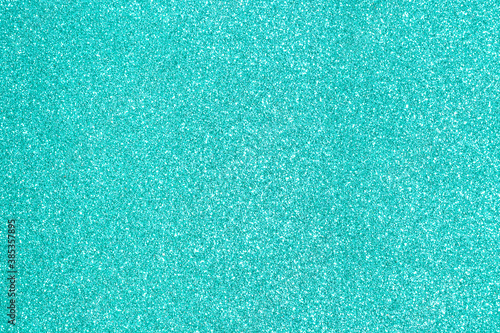 Shiny turquoise background. Turquoise glitter. Turquoise shiny paper. Festive background, abstraction.