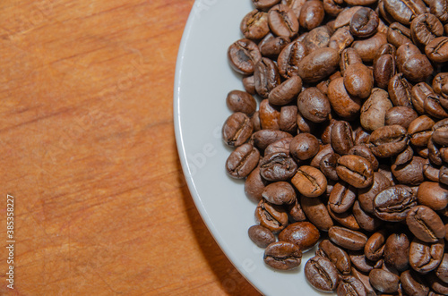 White plate with coffee beans wooden background photo