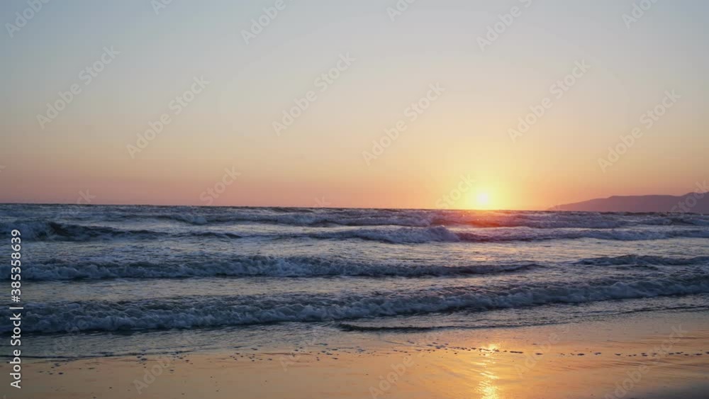 landscape of sea waves flows on sandy beach shore with sunset evening light dark mountain background time lapse landscape of sea waves flows on sandy beach shore with sunset evening light dark mountain background time lapse