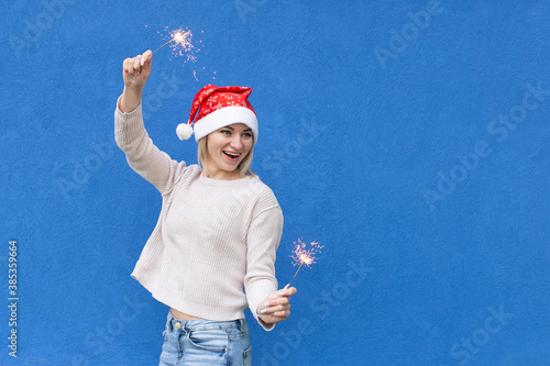 Beautiful girl on a blue background in a New Year's hat