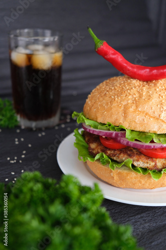  Delicious burger with soda in the background. Black background. advertising photo.