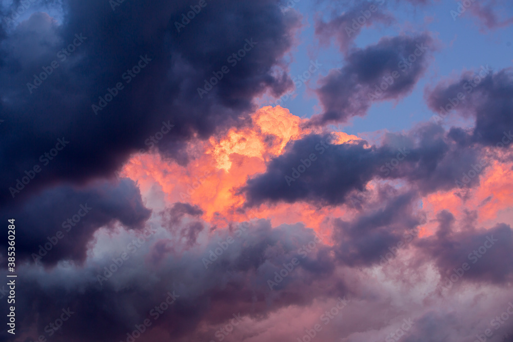 Dramatic and cloudy sky in a purple, blue and orange colors background