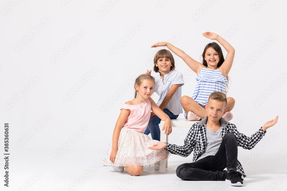 Fototapeta premium Happy young people playing together, copy space on empty white wall