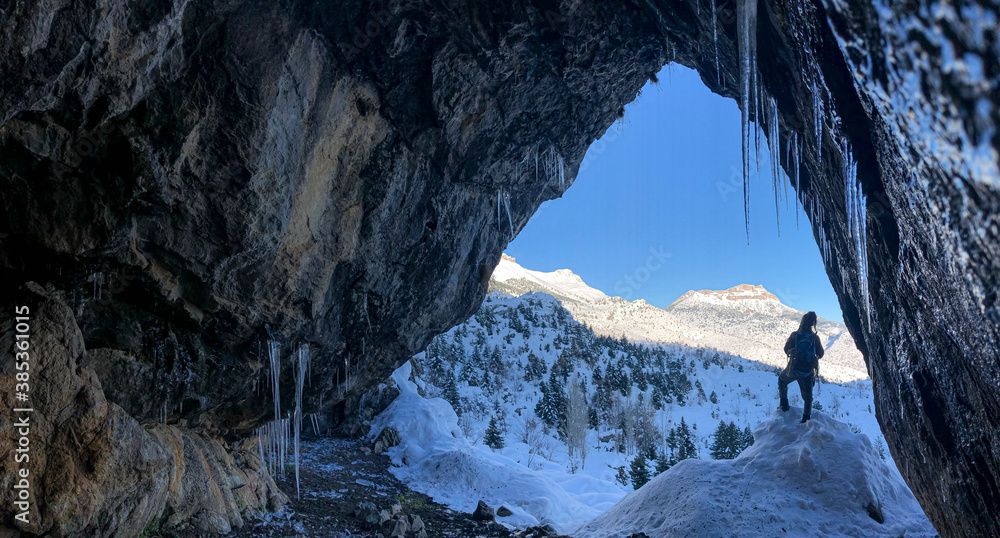 Curious looks from a beautiful cave on a cold winter day - obrazy, fototapety, plakaty 