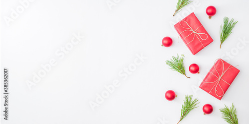 Flat lay border with red christmas decoration, pine branches on a white background © maria_lh