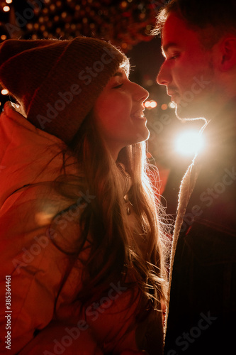 couple, girl and boy ice skating outdoor at rink at night