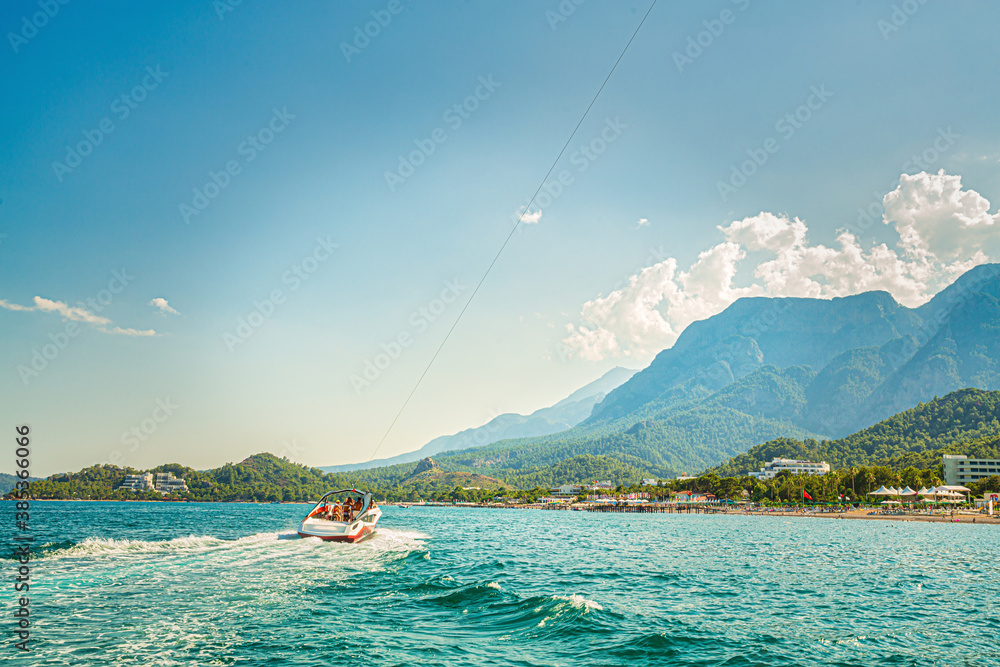 Fototapeta premium Fast boat on blue sea with mountain view, Kemer, Turkey