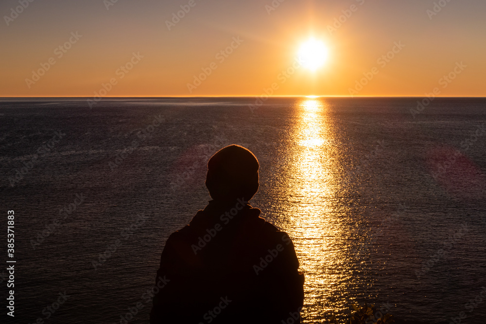 Man admiring the sunrise at Cap Bon-Ami, in the Forillon national park, Canada Man admiring the sunrise at Cap Bon-Ami, in the Forillon national park, Canada