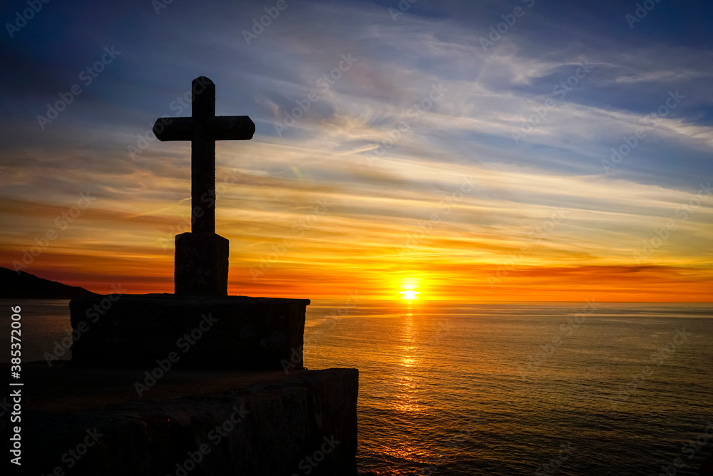 orange sunset or sunrise over the sea with the silhouette of a cross