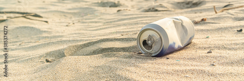 Aluminium can left on sand of beach. Garbage polluting the natural environment and pollution