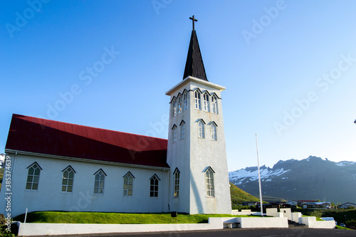 icelandic red church landscape with snowy mountains in the background