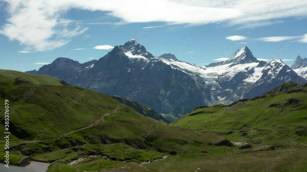 aerial view of beautiful mountain scenery with snow covered high mountain peaks and green grass during Summer. Schreckhorn Grindelwad First, Switzerland