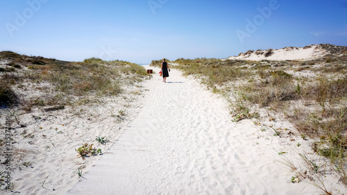 woman walking through the dunes and beach of Corrubedo photo