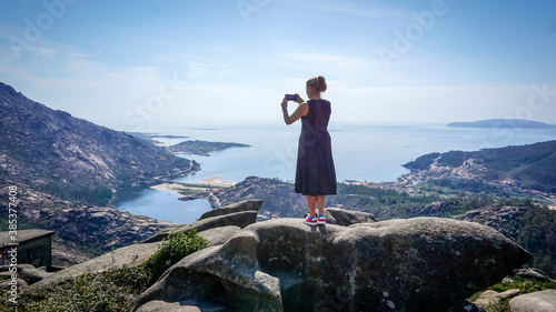woman taking photos at the ezaro viewpoint in dumbria, la Coruña photo