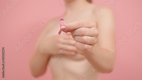 Close up  woman holding silk pink ribbon between her fingers. Breast cancer awareness month pink october. High quality 4k footage