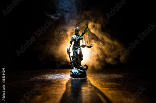 The Statue of Justice - lady justice or Iustitia / Justitia the Roman goddess of Justice on a dark fire background photo