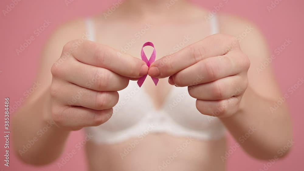 Close up, woman holding silk pink ribbon between her fingers. Breast cancer awareness month pink october. High quality 4k footage Close up, woman holding silk pink ribbon between her fingers. Breast cancer awareness month pink october. High quality 4k footage