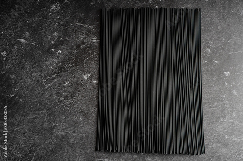 Black dry raw noodles on dark background photo
