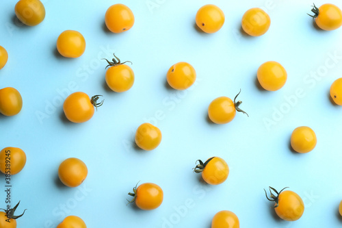 Yellow tomatoes on light blue background, flat lay