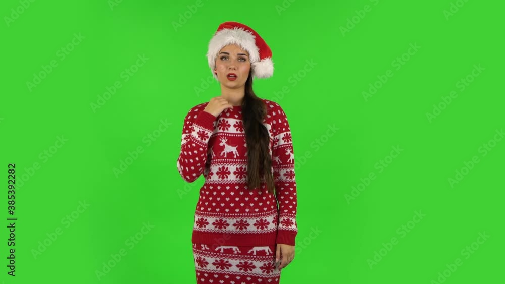 Sweety girl in Santa Claus hat is cooling herself by her hand, suffering from high temperature weather. Green screen Sweety girl in Santa Claus hat is cooling herself by her hand, suffering from high temperature weather. Green screen