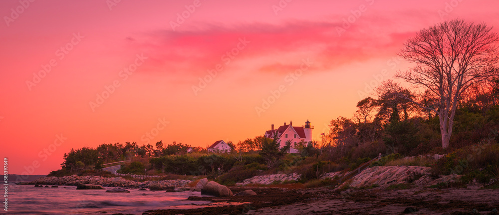 Pink Twilight Seascape over the Seashore Forest with Lighthouse in Autumn