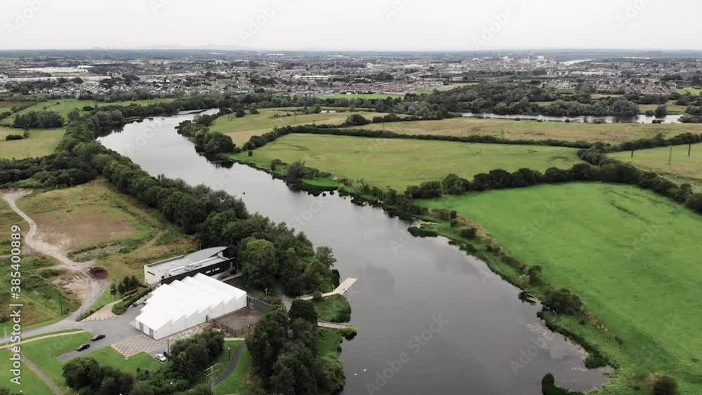 Aerial View of Shannon River With Limerick City in Skyline, Republic of Ireland. Green Fields on Riverbanks on Cloudy Summer Day. Drone Shot