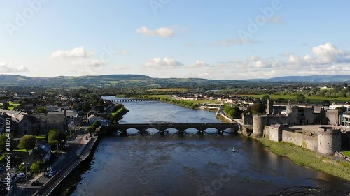 Aerial View of Limerick City, Ireland, Revealing View of Shannon River Riverside With King John's Castle and Residential Neighborhood, Pull Back Drone Shot photo