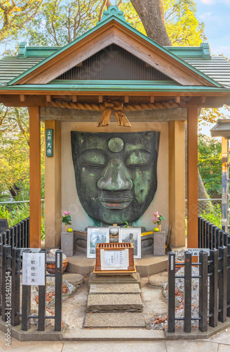 tokyo, japan - october 10 2020: Sculpture of the remains of the Ueno Daibutsu in the Kan'ei-ji temple depicting the face of the japanese buddha Shaka Nyorai restored after the Great Kantō earthquake. photo