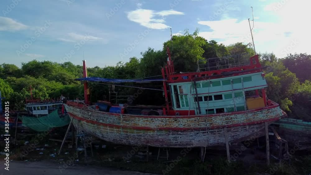 Fly up close to traditional wooden fishing boat in for repair SE Asia Fly up close to traditional wooden fishing boat in for repair SE Asia