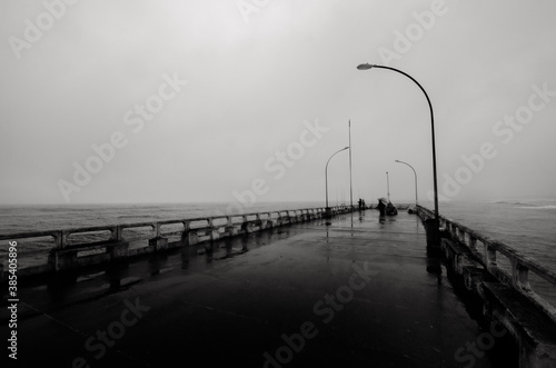 platarforma de pesca, pescadores, pesca no mar, pesca na chuva, pesca na praia.