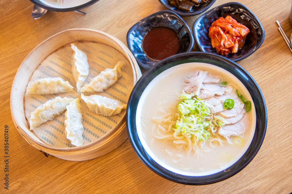 Korean traditional dumplings and soy milk noodle soup, Kong-Guksu served with kimchi and soy sauce Korean traditional dumplings and soy milk noodle soup, Kong-Guksu served with kimchi and soy sauce