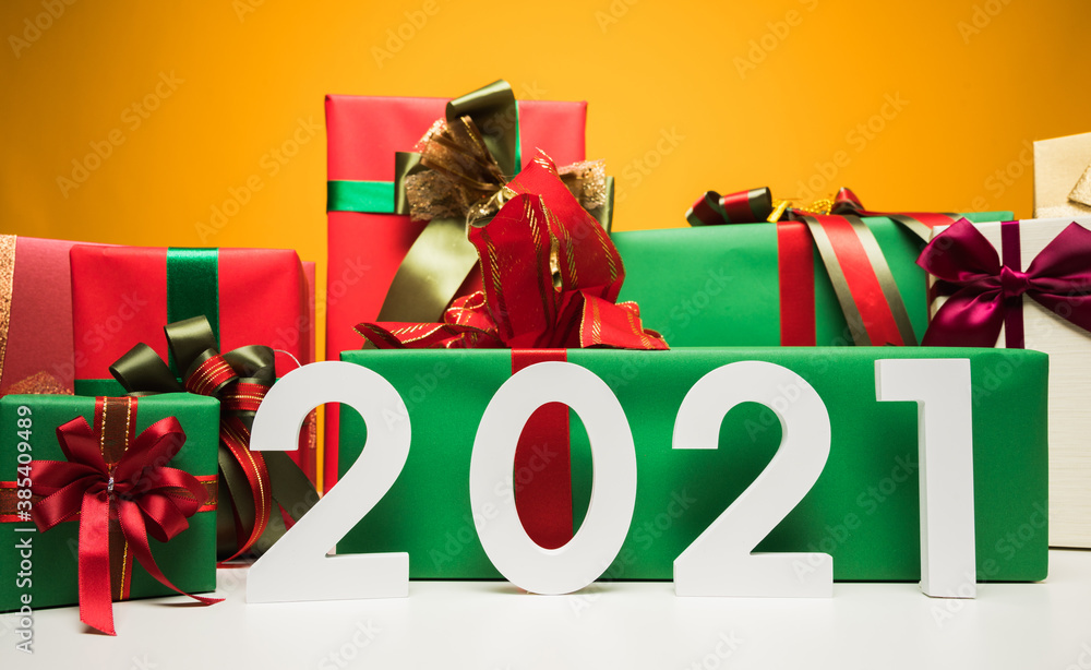 Fototapeta premium 2021 years. A lot of gift box mockup wrapped decorated with ribbon bow. Big pile of gift set stack on yellow background color. Merry christmas and Happy new year festival concept.