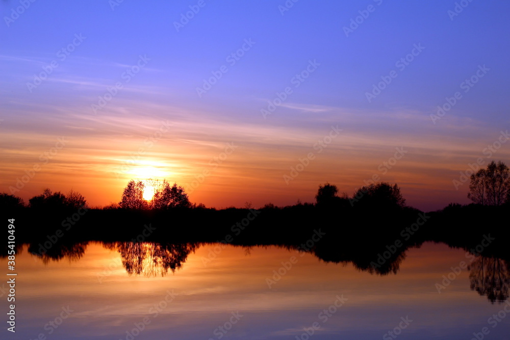 Bright sunset in summer over the lake