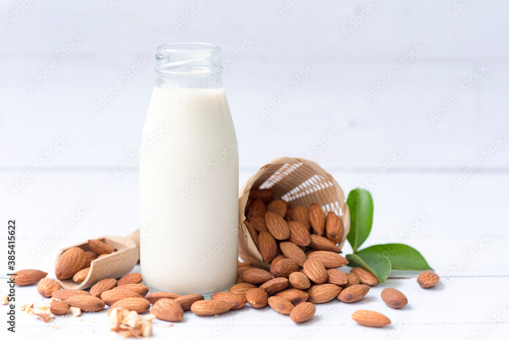 Homemade almond milk in a small bottle and almond in basket isolated on a white background, healthiest nuts and one of the best brain foods.Selective focus. Homemade almond milk in a small bottle and almond in basket isolated on a white background, healthiest nuts and one of the best brain foods.Selective focus.