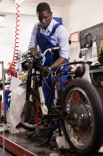 Service engineer repairing motorcycle in motorcycle service. High quality photo