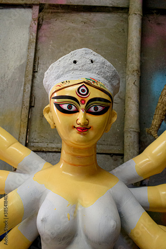 Clay idol of Goddess Devi Durga is in preparation for the upcoming Durga Puja festival at a pottery studio in Kolkata, West Bengal, India. Close Up. Selective focus. photo