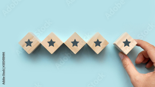 Positive rating in the form of five stars. The hand of a man puts up stars. Rating in social networks