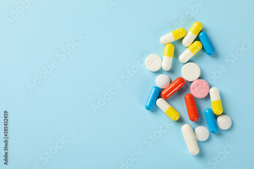 Fotografia Different pills on blue background, space for text