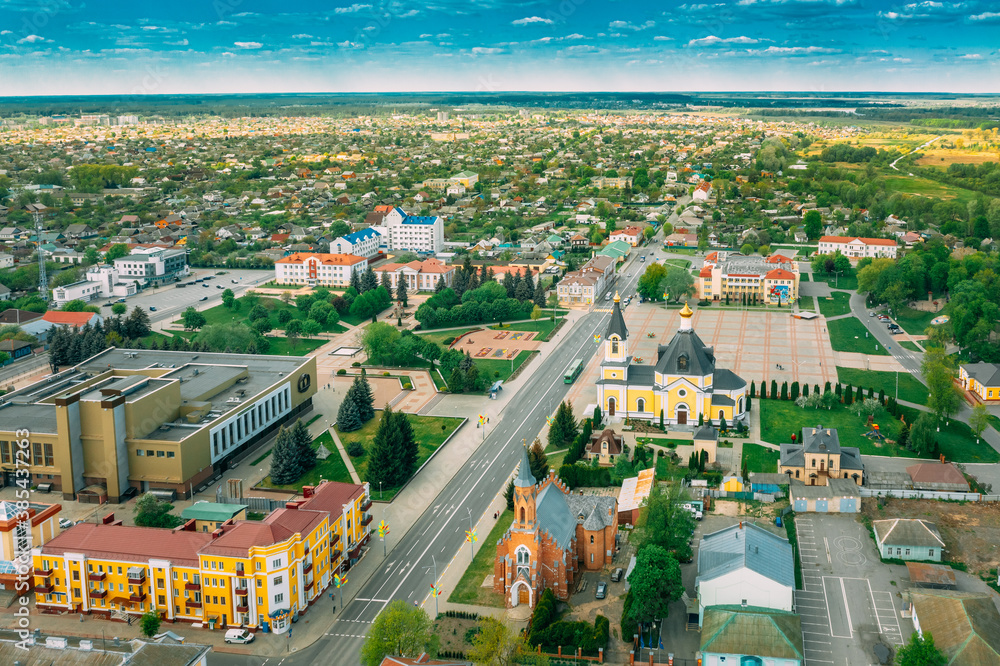Rechytsa, Belarus. Aerial View Of Residential Houses And Famous Landmarks Of Town: Holy Assumption Cathedral And Holy Trinity Church In Sunny Summer Day.