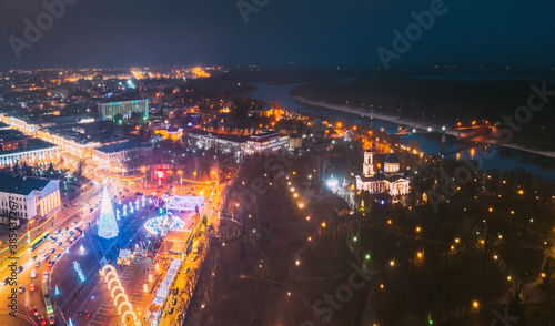 Gomel, Belarus. Main Christmas Tree And Festive Illumination On Square In Homel. New Year In Belarus. Aerial Night View. Peter And Paul Cathedral In Rumyantsevs And Paskeviches Park. Local Landmark