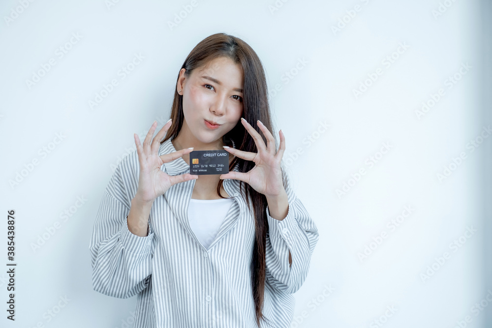 Portrait of a lovely young Asian beautiful woman with long hair holding a black credit card, her eyes sparklingly at the camera. Ready to pay shopping according to discounted products