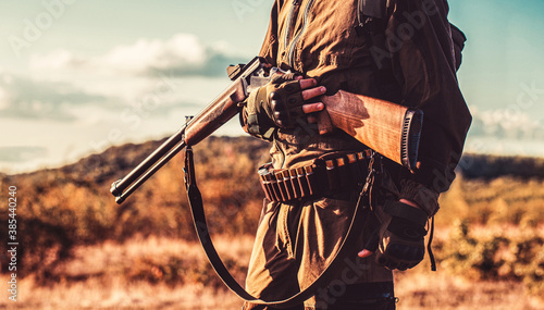 Quadro su tela Hunter with a hunting gun and hunting form to hunt in an autumn forest