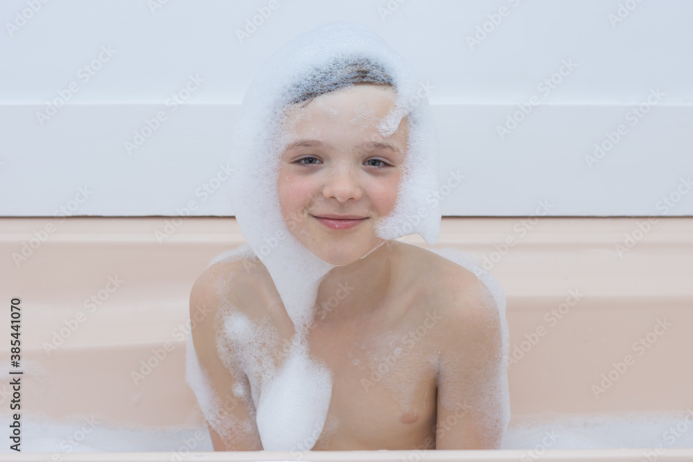 A young toddler boy sitting in the bath with foam on his face. A young toddler boy sitting in the bath with foam on his face.